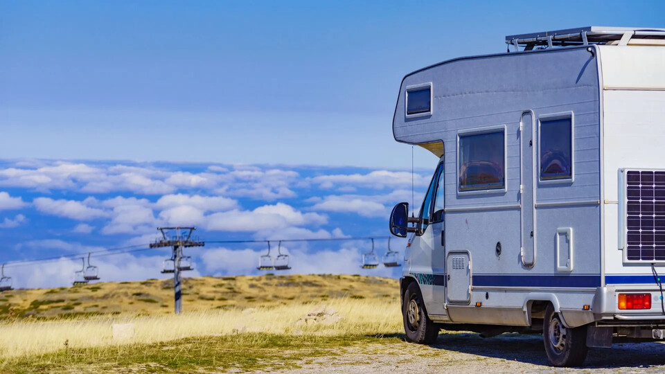 What to Take Camping - Person Relaxing on Recliner with Campervan in Background